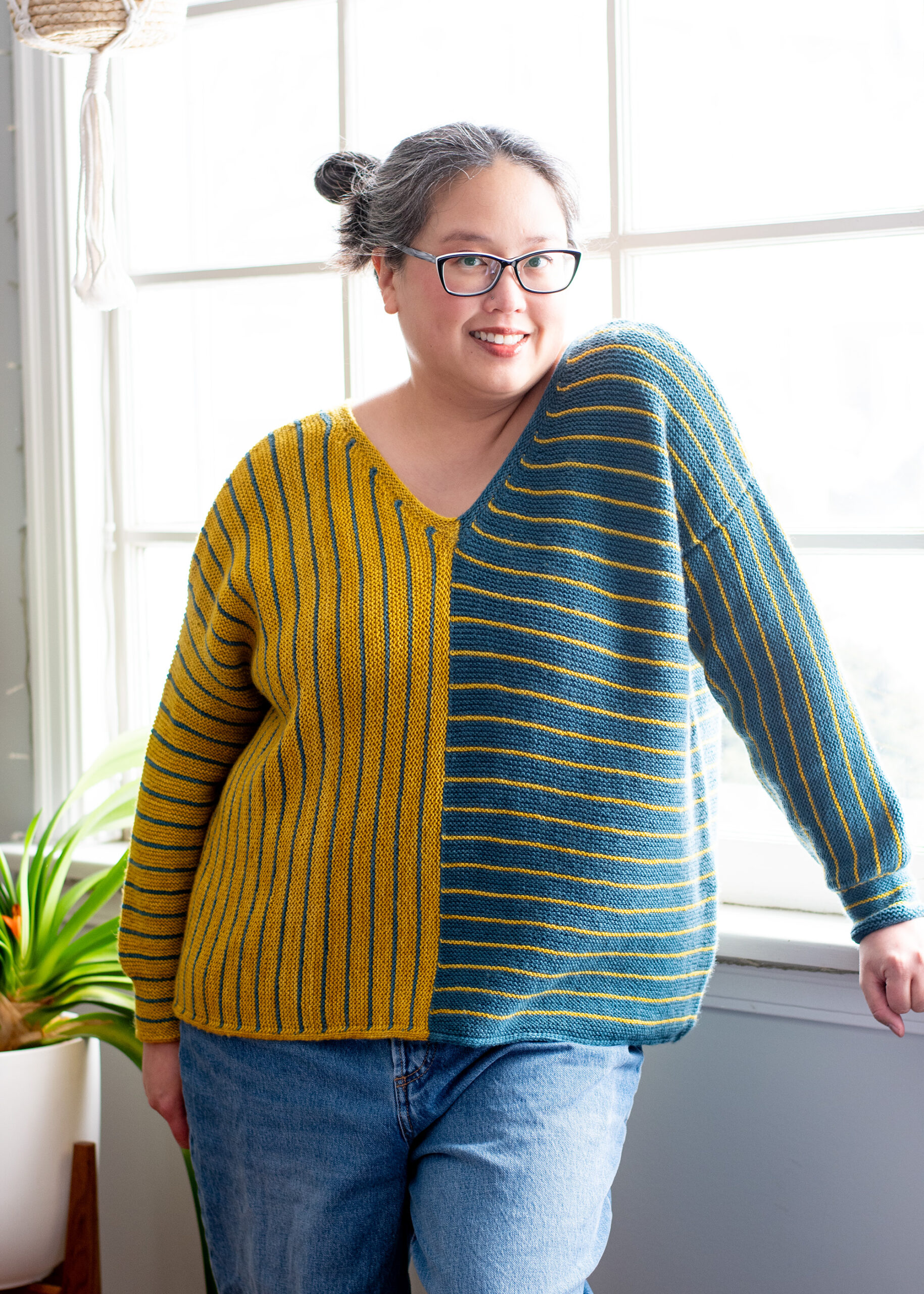 Laura wearing a pullover that's half yellow with blue vertical stripes and half blue with yellow horizontal stripes.